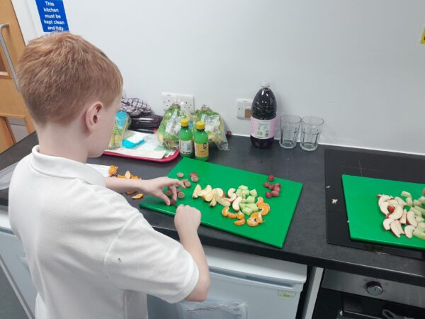 A learner enjoying their cooking session, making a healthy fruit salad.